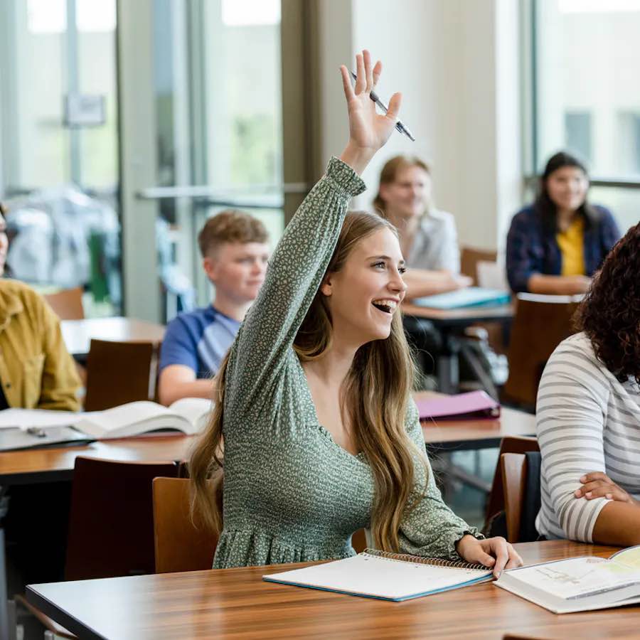 student raising hand in classroom