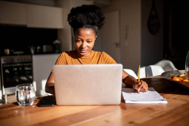 woman studying on a desk with a laptop and books